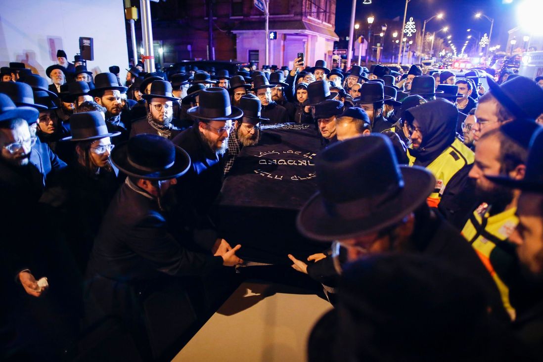 Orthodox Jewish men carry the casket with Mindel Ferencz who was killed in a kosher market that was the site of a gun battle in Jersey City, N.J.